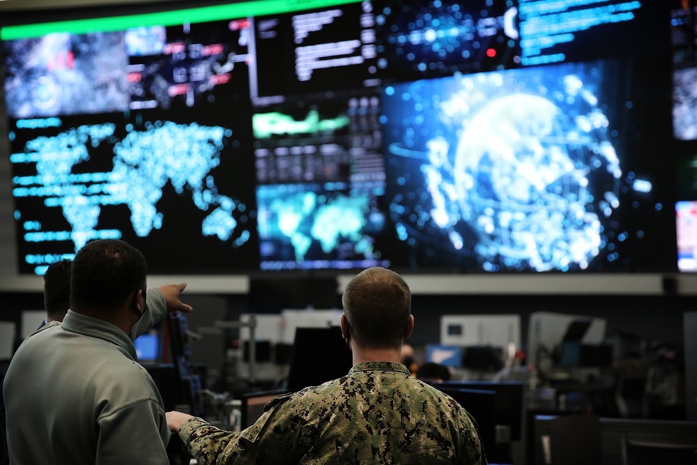 Personnel reviewing global network data in a cyber operations center